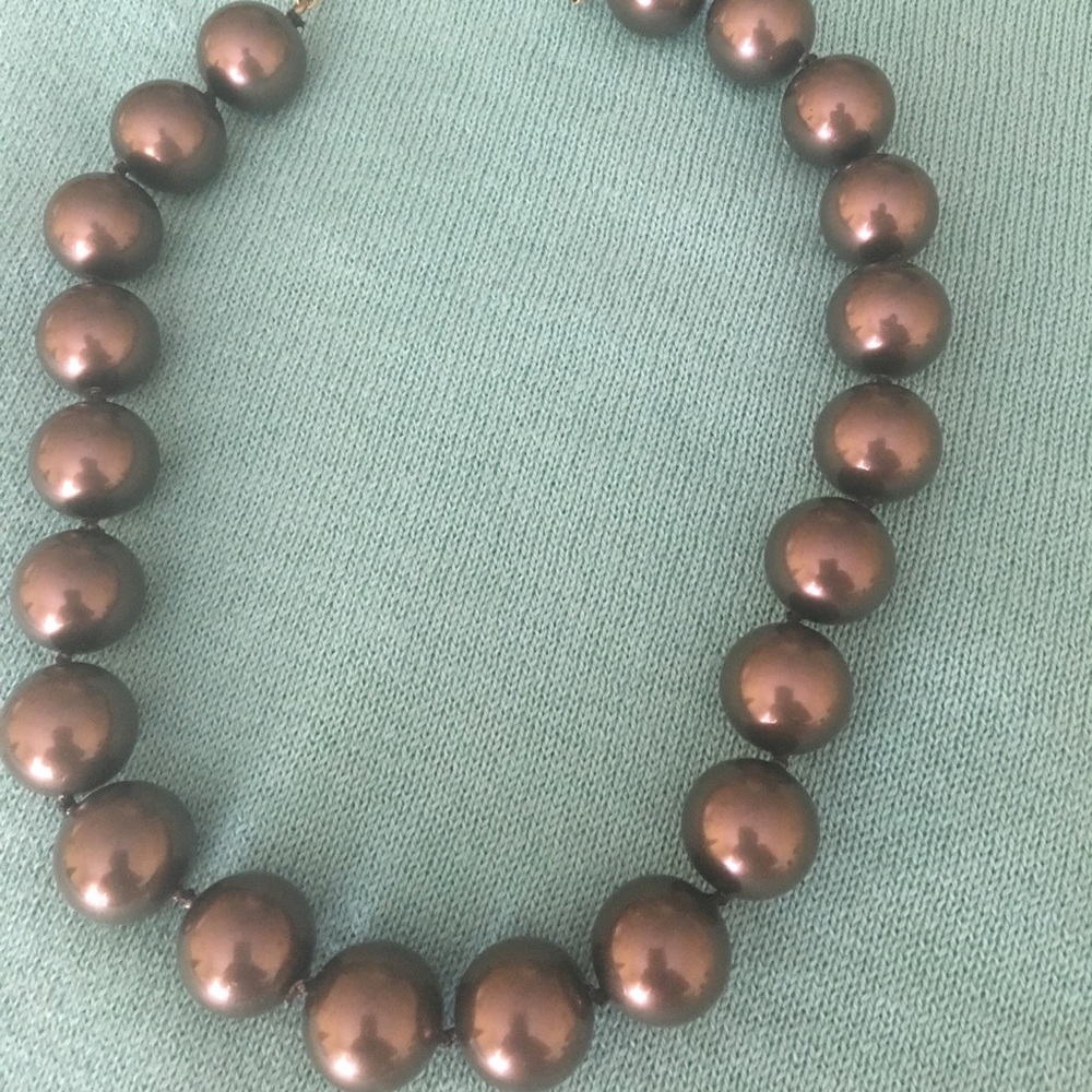 Chunky, pearl necklace with golden clasp closure.